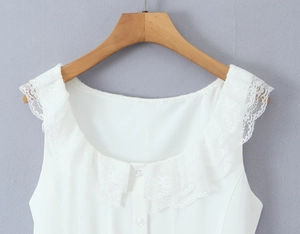 Detailed close-up of the white ruffle lace neckline and button-down front on the dress