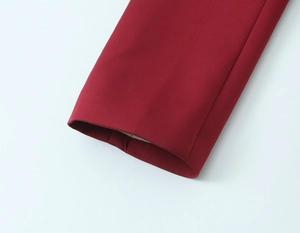 Detailed close-up of red woven fabric blazer cuff with high-quality stitching detail