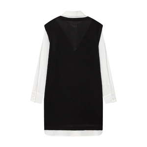 Detail van een tweedelige set met wit overhemd en zwart gebreid lang vest kleding