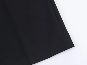 Gros plan du tissu tissé noir de qualité et des coutures précises du pantalon habillé