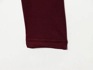 Close-up of double-needle stitching on burgundy knitted fabric showing hem detail