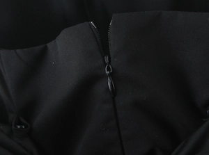 Gros plan d'une robe noire avec fermeture éclair invisible et texture de tissu tissé de qualité
