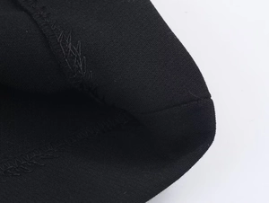 Vue macro détaillée des coutures renforcées sur les poignets de la veste de costume noire