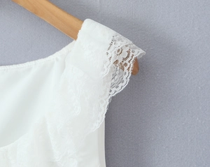 Close-up of intricate white floral lace trim and layered ruffles on a summer dress