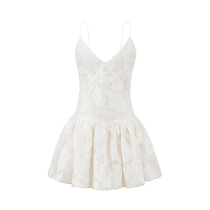 Détail de la robe mini blanche à col en V montrant le tissu jacquard floral et la taille haute
