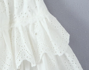 Close-up of white eyelet embroidery and layered ruffles on a summer skirt set
