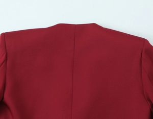 Detailed view of the shoulder stitching and collar on a wine red structured blazer