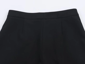 Détail du pantalon noir taille haute avec pinces précises et coutures ajustées de qualité