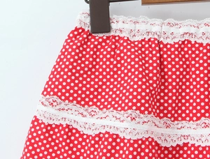 Detailed view of red polka dot skirt featuring intricate white lace ruffles and soft fabric