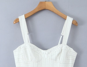 Détail de la bordure en dentelle florale et nœud sur le haut bustier vintage crème