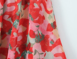 Detail of red and pink strawberry and cherry print fabric on summer crop top