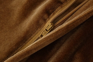 Detalle de la cremallera de metal y la textura de terciopelo de la chaqueta marrón