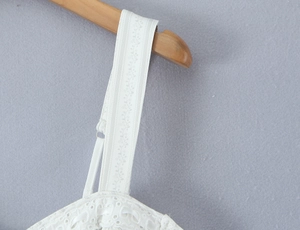 Détail d'une robe blanche en dentelle anglaise avec broderie florale sur les larges bretelles