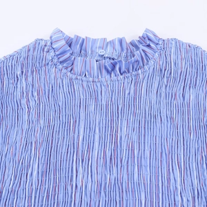 Detailansicht von Smock-Stoff und Rüschenkragen an einer blau gestreiften Damenbluse