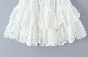 Detail of white Broderie Anglaise cotton skirt with tiered ruffles and intricate embroidery