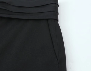 Détail de la taille noire avec plis triples et coutures soignées sur le vêtement