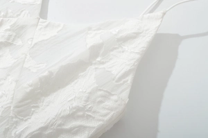 Gros plan sur la robe d'été blanche avec texture dentelle florale et fines bretelles