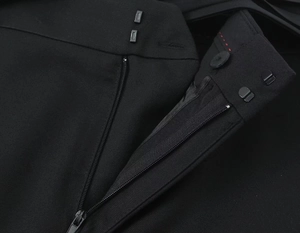 Détail macro d'un pantalon de costume avec fermeture à crochet et surpiqûre rouge