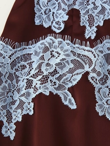 Detail of burgundy fabric with light blue floral eyelash lace and refined embroidery