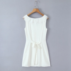 Close-up of white sleeveless dress showing lace ruffles and back waist bow tie detail