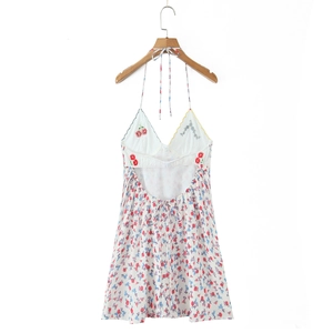 Close-up of floral embroidery on a white backless sundress with delicate ruffles