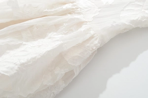 Détail de la broderie florale blanche et de la texture froncée de la robe d'été