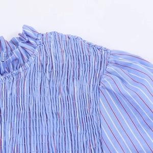 Detail der hellblau gestreiften Bluse mit Smok-Technik, Rüschenhals und Puffärmeln