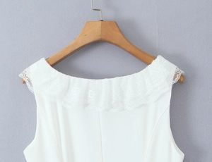 Close-up of elegant white sleeveless dress featuring intricate lace ruffle details on the neckline