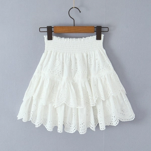 Close-up of white cotton Broderie Anglaise mini skirt with tiered layers and smocked waist