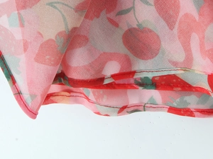 Detail of pink summer fabric featuring red strawberry and flamingo prints with neat stitching