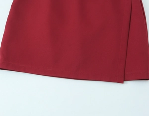 Detail view of burgundy wrap skirt hemline featuring precise double-needle stitching