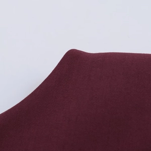Detailed macro view of the wine red knit fabric texture for casual summer dress