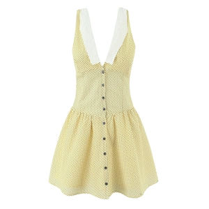 Detail of light yellow polka dot dress featuring a deep V-neck and delicate lace trim
