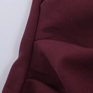 Close-up of wine red woven fabric showing smooth texture and fine stitching detail