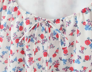 Detail of floral print summer dress neckline with adjustable self-tie bow string