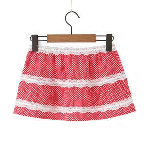 Detail of red polka dot mini skirt featuring three tiers of white lace trim decoration