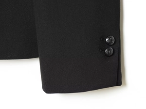 Detailed close-up of suit jacket cuffs with embossed lion shield decorative buttons