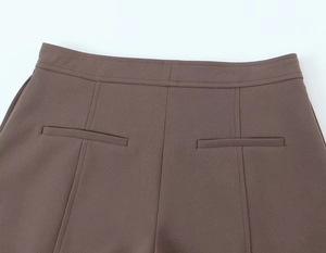 Detail of coffee brown trousers featuring back welt pockets and dual-stitching waistband