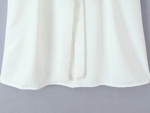 Detail shot of white summer dress showing smooth fabric hem and adjustable thin straps