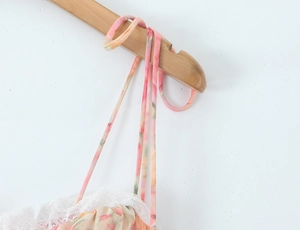 Détail d'une robe fleurie en mousseline avec dentelle blanche et fines bretelles chic
