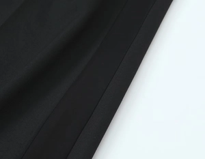 Gros plan sur la texture du tissu noir et les détails de la sangle lisse