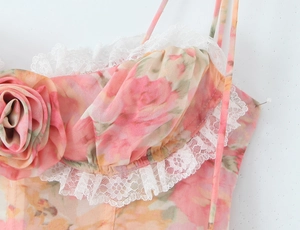 Détail d'une robe fleurie rose avec bordure en dentelle blanche et rose en tissu 3D