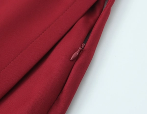Close-up of deep red woven fabric with matching seamless invisible zipper detail