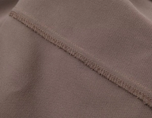 Close-up of premium double-stitched seams and inner lining on tan professional suit