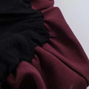 Detailed macro view of the pleated black and burgundy patchwork fabric texture