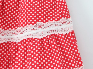 Detail of red polka dot fabric with white embroidery lace trim on a summer skirt set