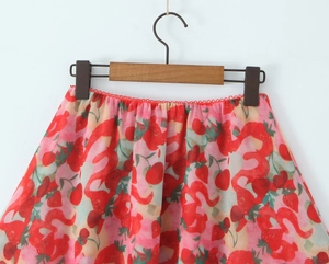 Detail of red strawberry print skirt featuring delicate scalloped lace embroidery waist