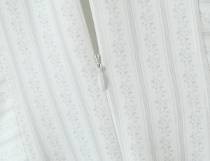 Détail de la fermeture éclair invisible et imprimé floral sur robe rayée blanche