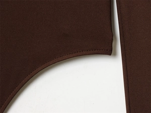 Close-up of precise stitching and fabric texture on a dark brown slim jumpsuit