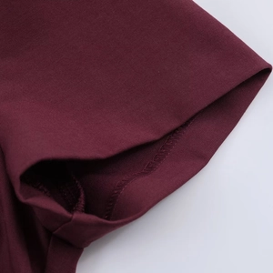 Macro shot of precise stitching and premium burgundy fabric texture on the dress sleeve